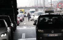 A person walks on the highway, during a protest in Belgrade, Serbia, Saturday, Jan. 15, 2022. Hundreds of environmental protesters demanding cancelation of any plans for lithium mining in Serbia took to the streets again, blocking roads and, for the first time, a border crossing. Traffic on the main highway north-south highway was halted on Saturday for more than one hour, along with several other roads throughout the country, including one on the border with Bosnia. (AP Photo/Darko Vojinovic)