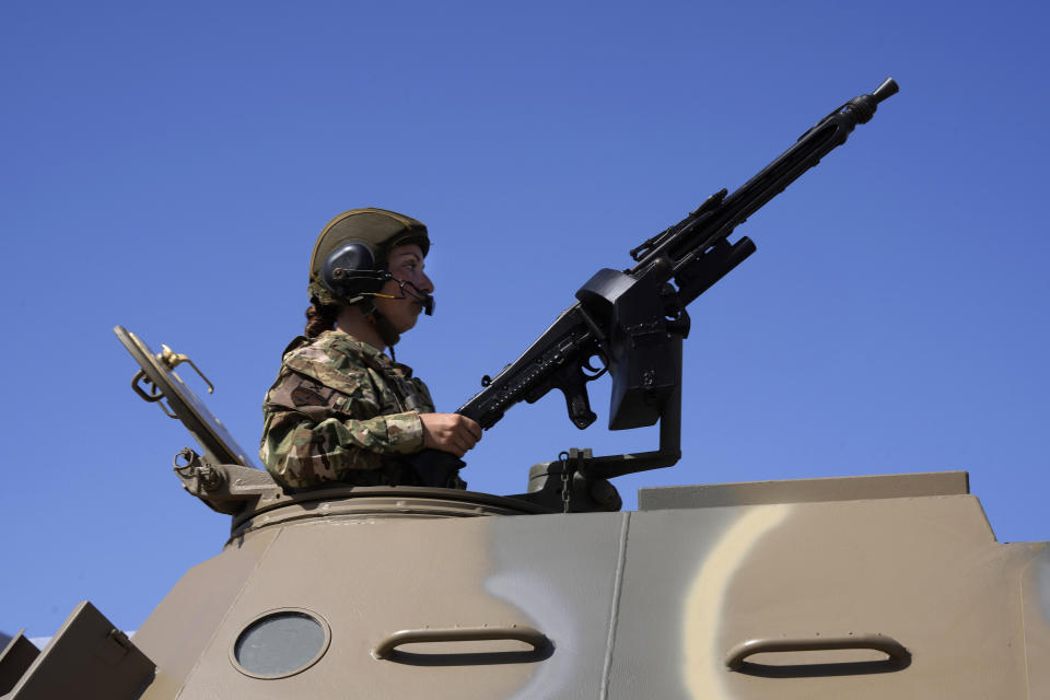 A female soldier sits on an armoured vehicle during a military parade marking the 62nd anniversary of Cyprus' independence from British colonial rule, in Nicosia, Cyprus, Saturday, Oct. 1, 2022. Cyprus gained independence from Britain in 1960 but was split along ethnic lines 14 years later when Turkey invaded following a coup aimed at uniting the island with Greece. (AP Photo/Petros Karadjias)