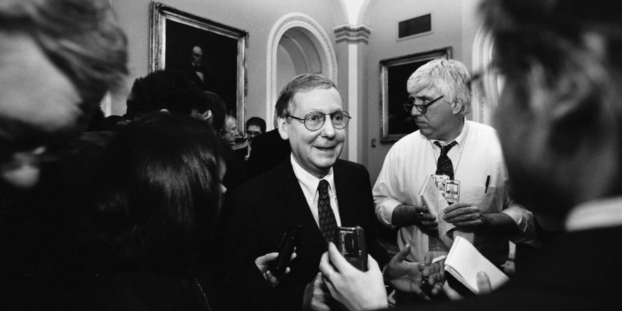 Republican Sen. Mitch McConnell talks to reporters in the hallways of the U.S. Capitol Building during the Senate Impeachment Trial of Bill Clinton, Jan. 9, 1999 in Washington, DC.