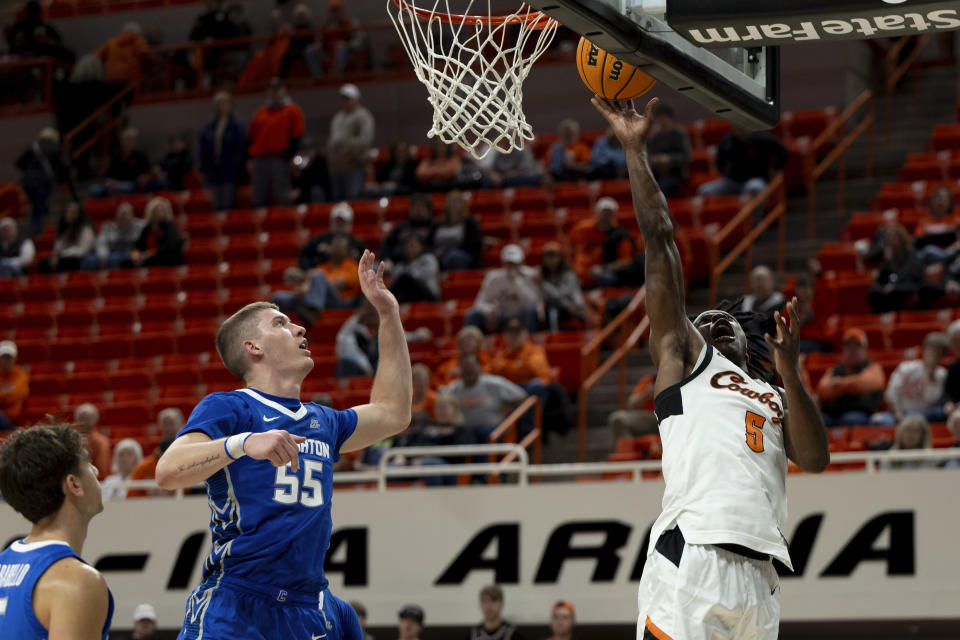 Oklahoma State guard Quion Williams (5) shoots the ball in front of Creighton guard Baylor Scheierman (55) in the second half of an NCAA college basketball game, Thursday, Nov. 30, 2023, in Stillwater, Okla. (AP Photo/Mitch Alcala)
