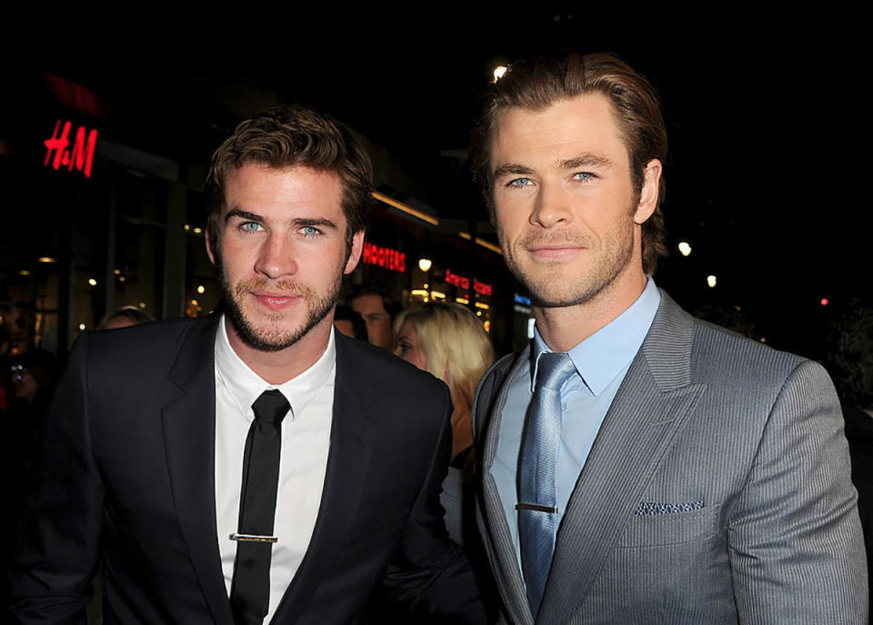 Liam in a black suit jacket and tie, Chris in a grey suit jacket and blue shirt and tie