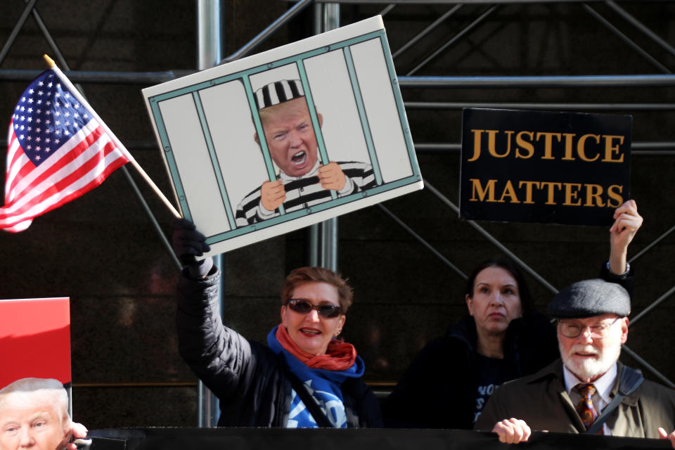 dpatopbilder - 21.03.2023, USA, New York: Demonstranten protestieren vor einem Gerichtsgebäude gegen den früheren US-Präsidenten Trump und halten ein Bild, das Trump hinter Gittern zeigt und ein Plakat mit der Aufschrift 