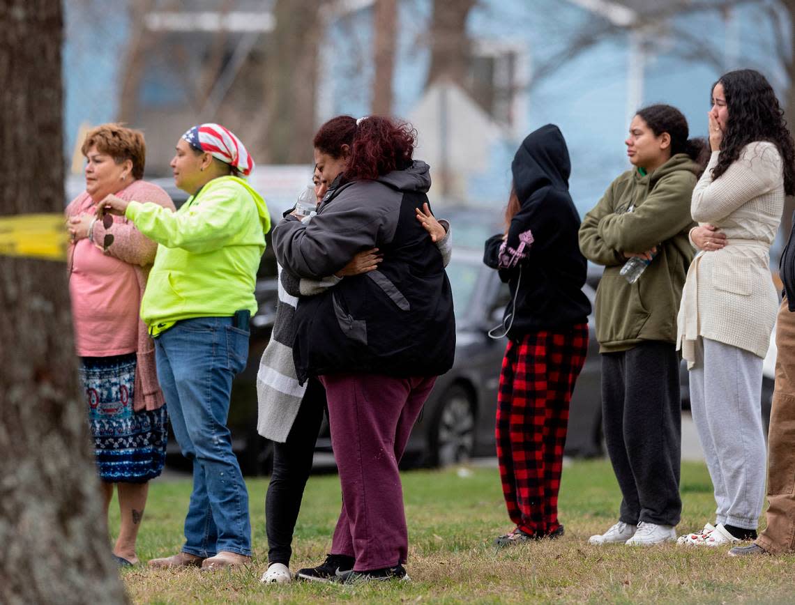 People gather near the intersection of Hudson Avenue and North Buchanan Boulevard as law enforcement investigate a homicide on Wednesday, March 22, 2023, in Durham, N.C.