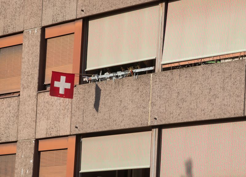 Switzerland's national flag flies in front of a balcony in Zurich