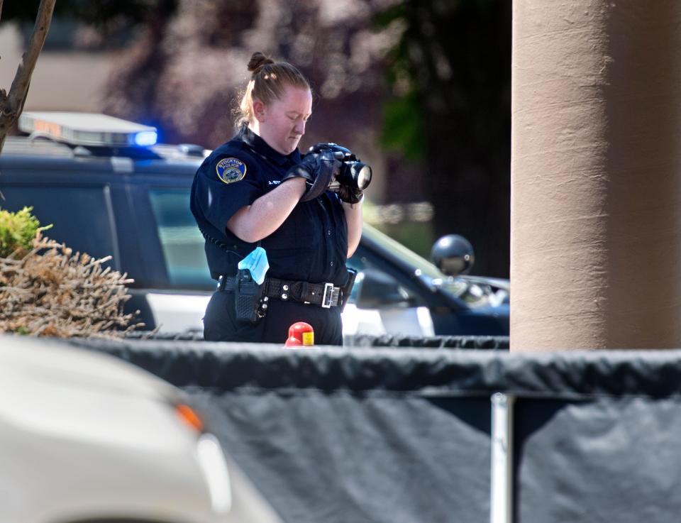 A Stockton Police evidence technician photographs the scene of a homicide outside of the Golden 1 Credit Union at Sherwood Mall in Stockton. Before 11 a.m. police received a report of a shooting outside of the credit union. Officers located a man who had been shot and medics declared him dead at the scene.