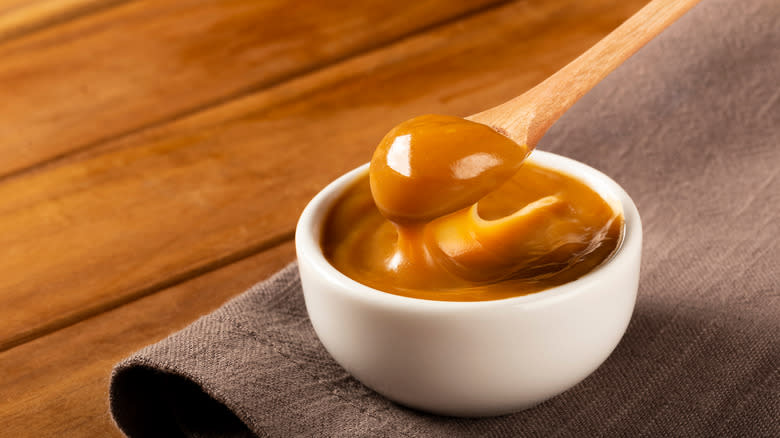 Wooden spoon scooping sauce