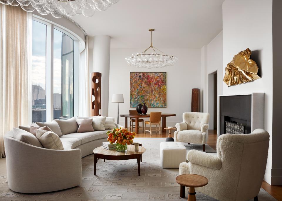 Lighting designer Nathan Orsman assisted in sourcing fixtures like the pair of Pelle bubble chandeliers in the combined living and dining room. “I love to use lighting as both a real source of light, and as sculpture in the space. With high ceilings, you really have to animate that huge volume that’s left above,” says Scott. In response to the apartment’s curved glass windows, a custom sofa arcs in the opposite direction, facing an inviting pair of soft shearling armchairs. His clients’ appreciation of tactile artwork comes through in the crinkled copper piece by Mareo Rodriguez and textured Larry Poons painting.