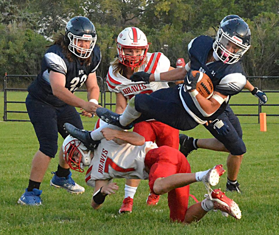 Great Plains Lutheran running back Micah Holien is upended by Britton-Hecla's Jace Rein during their season-opening high school football game on Friday, Aug. 18, 2023 at Watertown Stadium. Looking on are GPL's Jasper Cody and Britton-Hecla's Dashel Davidson.