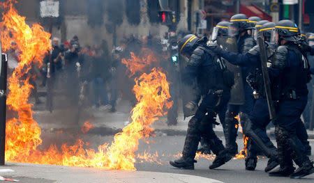 French CRS riot police protect themselves from flames during clashes at the traditional May Day labour union march in Paris, France, May 1, 2017. REUTERS/Gonzalo Fuentes