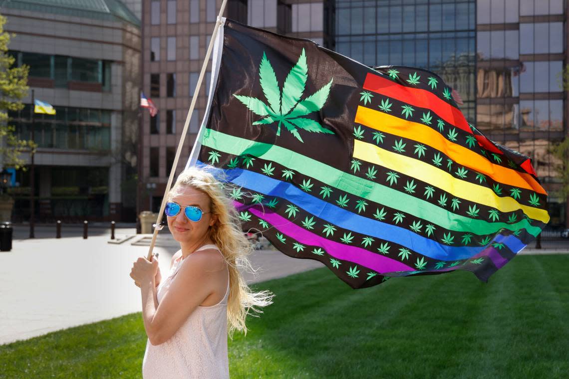 Samantha Farrell with Sensible Movement Coalition holds a flag depicting a cannabis leaf at a rally in support of legalized marijuana, April 20, 2023, outside the Statehouse in Columbus, Ohio.