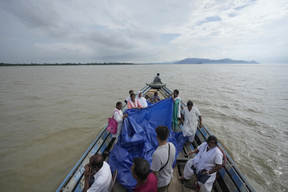 Health officers hold up a tarpaulin to cover 25-year-old Jahanara Khatoon as she delivers a baby on a boat over the River Brahmaputra, in the northeastern Indian state of Assam, Wednesday, July 3, 2024. (AP Photo/Anupam Nath)