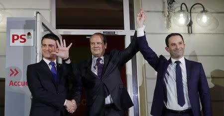 Former French education minister Benoit Hamon (R), winner after partial results in the second round of the French left's presidential primary election, reacts as he stands with former prime minister Manuel Valls (L) and French Socialist Party First Secretary Jean-Christophe Cambadelis (C) at their party headquarters in Paris, France, January 29, 2017. REUTERS/Philippe Wojazer