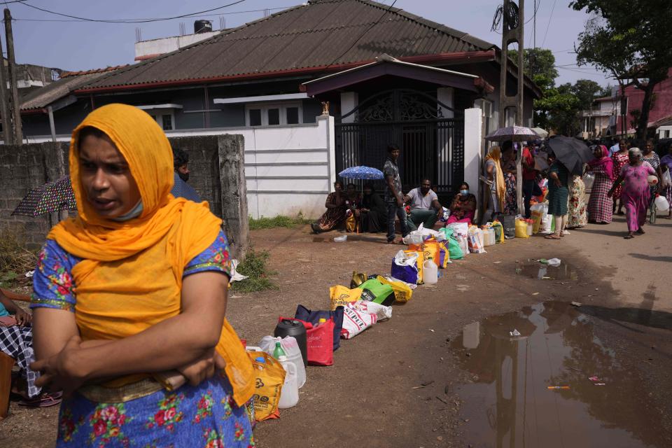 Sri Lankans wait in a queue to buy kerosene oil for cooking outside a fuel station in Colombo, Sri Lanka, Wednesday, May 11, 2022. Sri Lanka's defense ministry ordered security forces on Tuesday to shoot anyone causing injury to people or property to contain widespread arson and mob violence targeting government supporters. (AP Photo/Eranga Jayawardena)