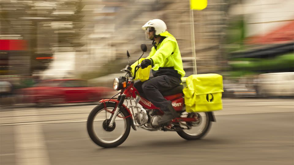 Pictured is an Australia Post postie riding a motorbike. 