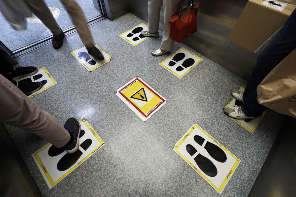 Social distancing stickers are viewed in an elevator at a shopping building Monday, Sept. 28, 2020, in Tokyo. The Japanese capital confirmed more than 70 coronavirus cases on Monday. (AP Photo/Eugene Hoshiko)