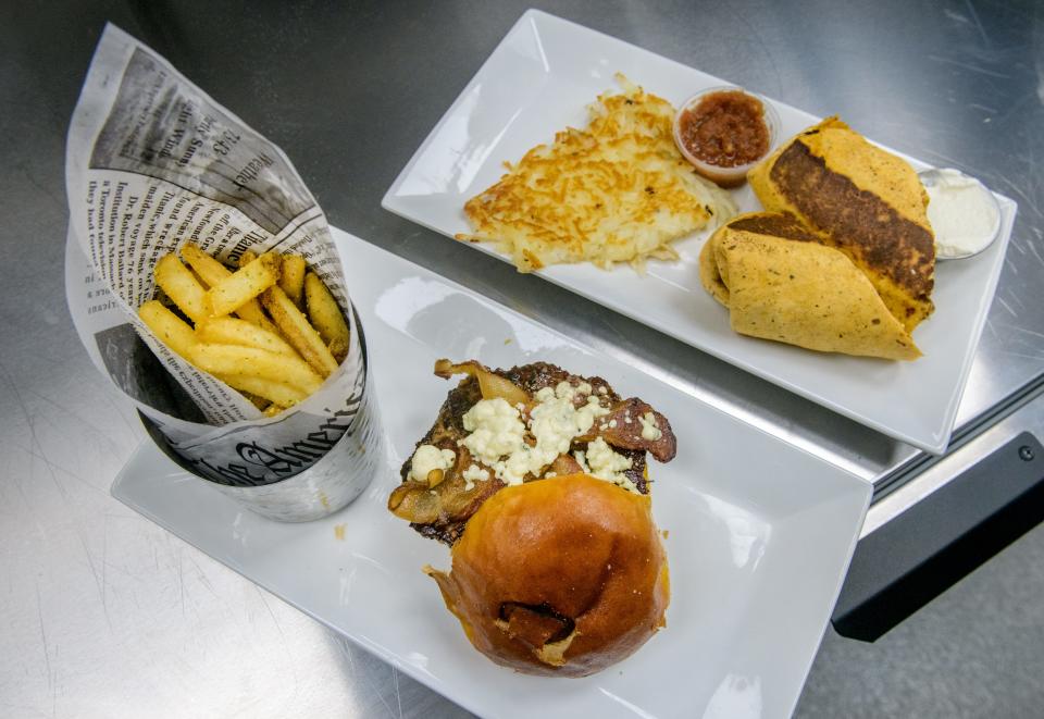 A burger topped with bacon and smoked blue cheese and a breakfast burrito with hash browns wait to be delivered to diners at the Childers Eatery at 815 Camp St. in East Peoria.