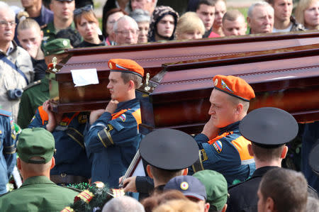 Russian Emergencies Ministry members carry coffins during a memorial ceremony before the funeral of victims of an attack on a local college in the city of Kerch, Crimea October 19, 2018. REUTERS/Pavel Rebrov