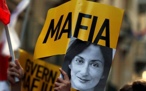 A protester holds a photo of murdered journalist Daphne Caruana Galizia during a demonstration in Valletta on Dec 8, 2019 - Credit: Reuters