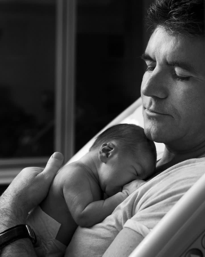 We never thought we'd see the day but Simon Cowell has become a dad! The 54-year-old X Factor judge looked every bit the doting dad as he cuddled his baby boy Eric in some intimate shots taken by a friend at Lenox Hill Hospital in Manhattan, just one day after baby Eric's birth on Feb. 14, 2014.