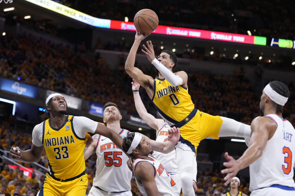 Indiana Pacers guard Tyrese Haliburton (0) is fouled by New York Knicks guard Miles McBride while driving to the basket during the second half of Game 3 in an NBA basketball second-round playoff series, Friday, May 10, 2024, in Indianapolis. (AP Photo/Michael Conroy)
