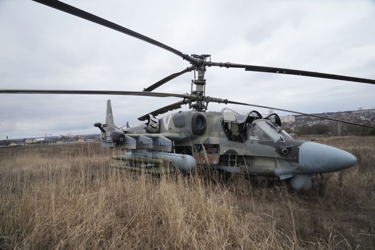 A Russian Ka-52 helicopter gunship is seen in the field after a forced landing Kyiv, Ukraine, Thursday, Feb. 24, 2022. Russia on Thursday unleashed a barrage of air and missile strikes on Ukrainian facilities across the country. (AP Photo/Efrem Lukatsky)