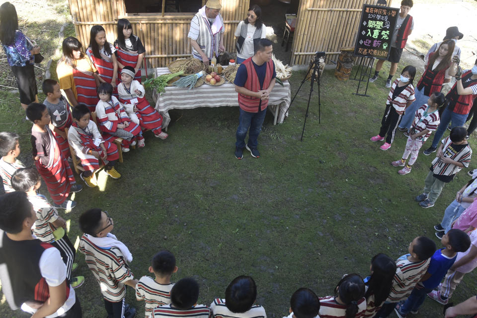 全校師生共同圍繞在泰雅傳統建築旁，期望泰雅文化代代傳承。