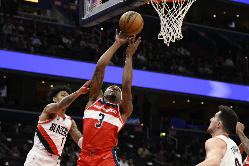 Washington Wizards guard Bradley Beal (3) goes to the basket past Portland Trail Blazers guard Anfernee Simons (1) and forward Drew Eubanks, right, during the first half of an NBA basketball game, Friday, Feb. 3, 2023, in Washington. (AP Photo/Nick Wass)