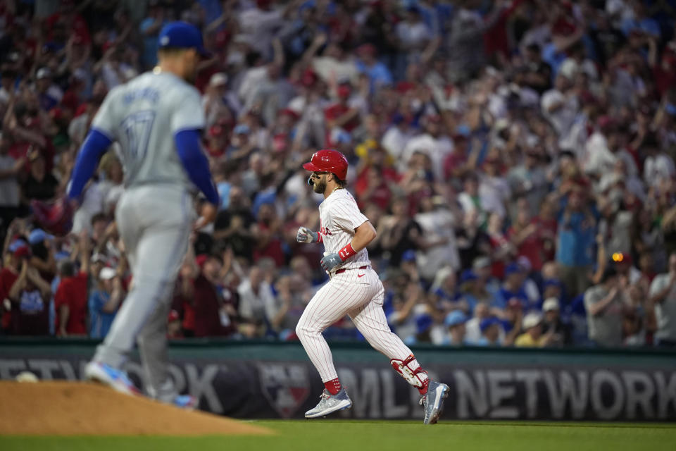 Philadelphia Phillies' Bryce Harper, right, rounds the bases after hitting a grand slam against Toronto Blue Jays pitcher Jose Berrios during the fourth inning of a baseball game, Tuesday, May 7, 2024, in Philadelphia. (AP Photo/Matt Slocum)