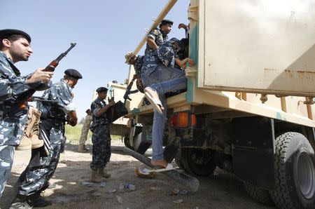 Shiite volunteers, who have joined the Iraqi army to fight against the predominantly Sunni militants from the radical Islamic State of Iraq and the Levant (ISIL) who have taken over Mosul and other northern provinces, climb into a truck in Baghdad, June 18, 2014. REUTERS/Ahmed Saad