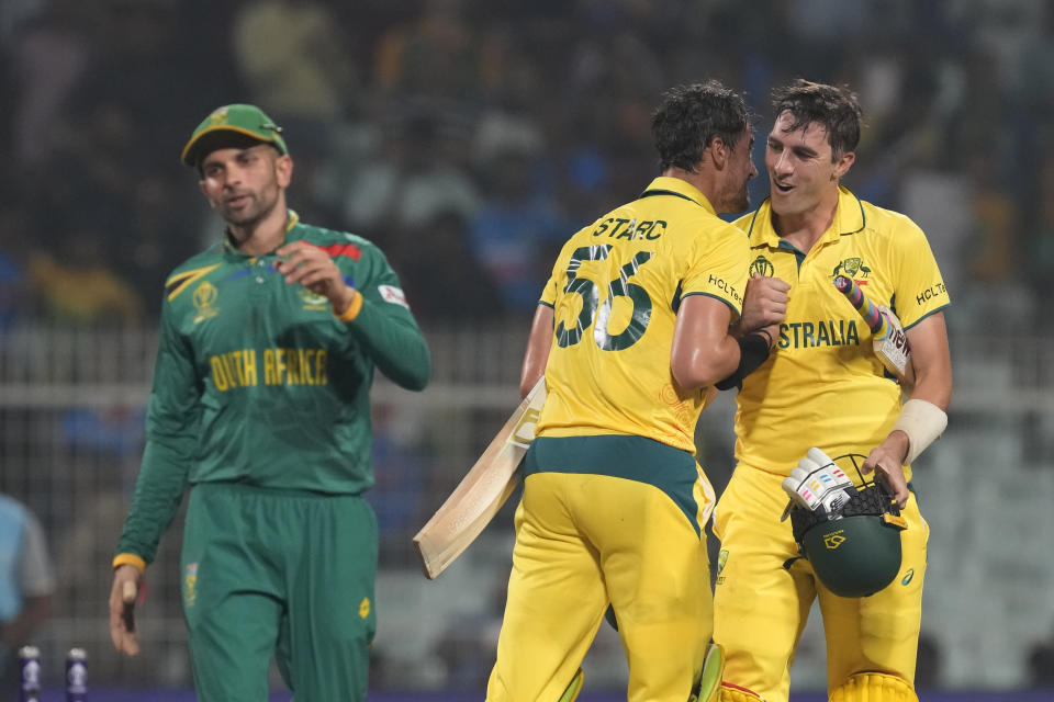 Australia's captain Pat Cummins and Mitchell Starc celebrate their win in the ICC Men's Cricket World Cup second semifinal match with South Africa in Kolkata, India, Thursday, Nov. 16, 2023. (AP Photo/Bikas Das)