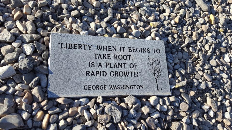 A plaque installed by Porter Buckley and his father at the base of the new flagpole outside the CSI Refugee Center. (Photo: Chris Wilson/Yahoo News)