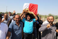 Mourners chant slogans against the al-Qaida breakaway group Islamic State of Iraq and the Levant (ISIL), while carrying a flag-draped coffin of Ammar Tueni, 24, a policeman killed in a car bomb attack during his funeral procession in Hillah, about 60 miles (95 kilometers) south of Baghdad, Iraq, Thursday, April 24, 2014. The Shiite-dominated city of Hillah has seen sporadic violence recently. Last month, a suicide car bomber hit another checkpoint in same area, killing 36 people. Iraq has seen a spike in violence since last year, with the death toll climbing to its highest levels since the worst of the country's sectarian bloodletting between 2006 and 2008. The U.N. says 8,868 people were killed in 2013, and more than 1,400 people were killed in the first two months of this year. (AP Photo/Karim Kadim)