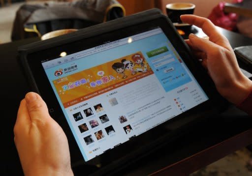 A woman views the Chinese social media website Weibo at a cafe in Beijing. China has closed 42 websites and deleted more than 210,000 posts since mid-March in a crackdown on online "rumours" as a major political scandal rocked the country