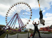 Canadian escape artist Dean Gunnarson is lifted by a crane while tied up in a straight jacket and with the rope on fire during a Royal Melbourne Show preview at the Melbourne Showgrounds on 23 September in Melbourne, Australia.