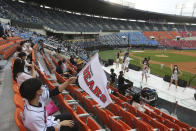 Fans wearing face masks to help protect against the spread of the new coronavirus watch the KBO league game between Doosan Bears and LG Twins in Seoul, South Korea, Sunday, July 27, 2020. Masked fans hopped, sang and shouted cheering slogans in baseball stadiums in South Korea on Sunday as authorities began bringing back spectators in professional sports games amid the coronavirus pandemic. (AP Photo/Ahn Young-joon)