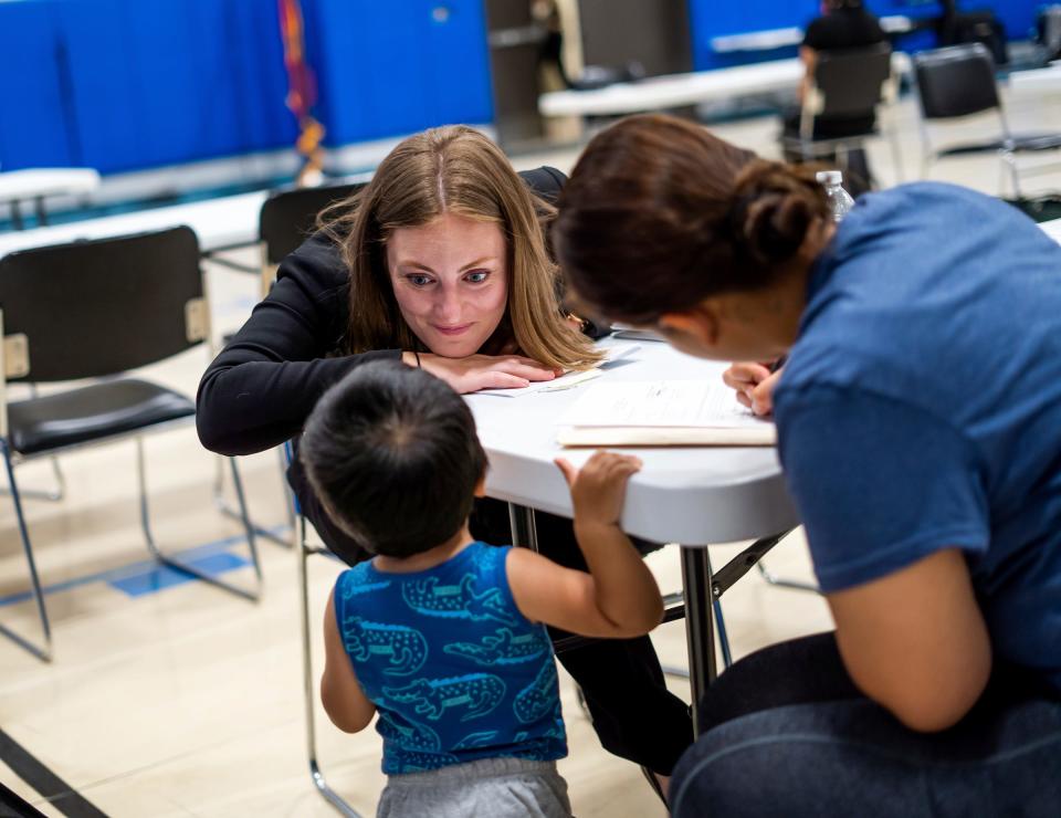 Detroit Mercy School of Law third-year student Savanna Polimeni, center, jokes with a child while helping his mother with filling out forms during the William Booth Legal Aid Clinic at the Salvation Army Detroit Harbor Light on Thursday, June 1, 2023. The clinic is the Salvation Army's only free legal service provider in the world, serving low-income residents in metro Detroit. In Detroit, three attorneys take on more than 1,500 cases a year and are constantly inundated with calls for help.