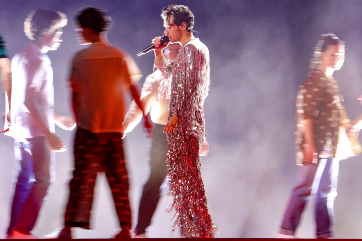 A male singer performs onstage.