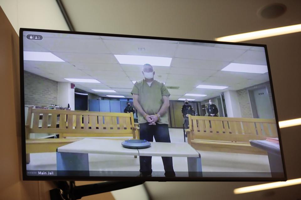 Former Columbus police officer Adam Coy is seen remotely on a television during his initial appearance on Friday, Feb. 5, 2021 at the Franklin County Common Pleas Courthouse in Columbus, Ohio. Coy was arraigned on four charges in the December 2020 police shooting death of Andre Hill, a Black man. Coy was charged with one count of murder, one count of felonious assault and two counts of dereliction of duty, one of which was for failure to render aid to Hill after he was shot. His bond was set at $3 million.