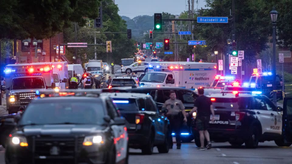 Law enforcement officers gather on Franklin Avenue in Minneapolis after two people were killed and several others were wounded Thursday. - Ben Hovland/Minnesota Public Radio/AP