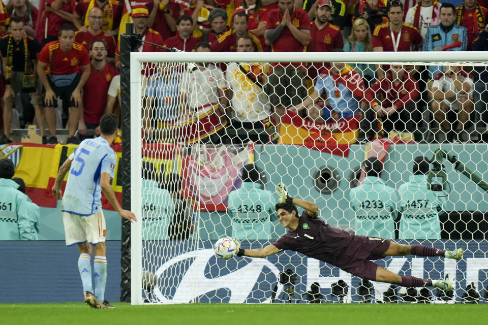 Morocco's goalkeeper Yassine Bounou stops a penalty shot by Spain's Sergio Busquets during a penalty shootout of the World Cup round of 16 soccer match between Morocco and Spain, at the Education City Stadium in Al Rayyan, Qatar, Tuesday, Dec. 6, 2022. (AP Photo/Francisco Seco)