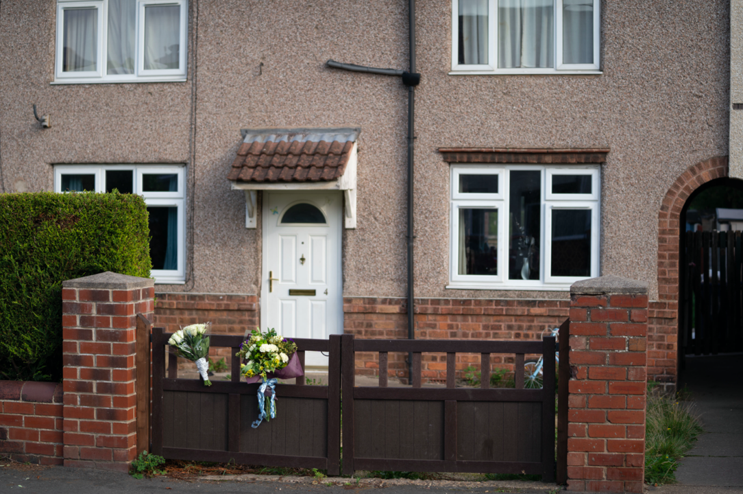 Flowers are left outside the house where the baby was mauled by a dog. (SWNS)