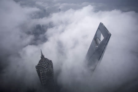 FILE PHOTO - Skyscrapers Shanghai World Financial Center (R) and Jin Mao Tower are seen during heavy rain at the financial district of Pudong in Shanghai May 15, 2015. REUTERS/Aly Song/File Photo