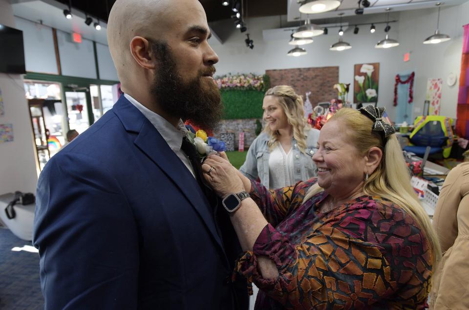 Rainbow Wedding Chapel owner Selecia Young-Jones helps Mike Estronza with his boutonniere just before he takes his wedding vows on Valentine's Day in downtown Jacksonville.