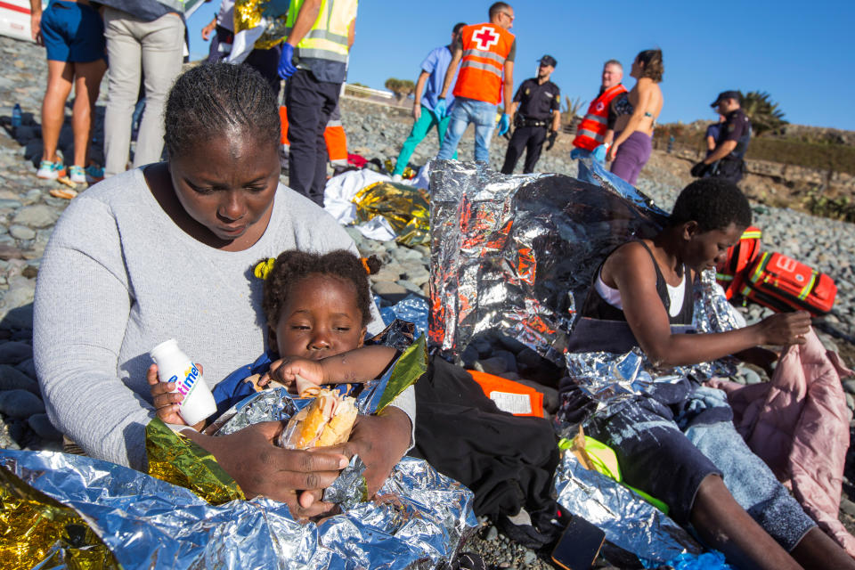 A migrant sits with her child.