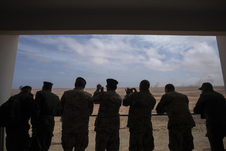 Observers from Europe, Africa and Asia use their phones to record a large scale drill as they attend the African Lion military exercise, in Tantan, south of Agadir, Morocco, Friday, June 18, 2021. The U.S.-led African Lion war games, which lasted nearly two weeks, stretched across Morocco, a key U.S, ally, with smaller exercises held in Tunisia and in Senegal, whose troops ultimately moved to Morocco. (AP Photo/Mosa'ab Elshamy)