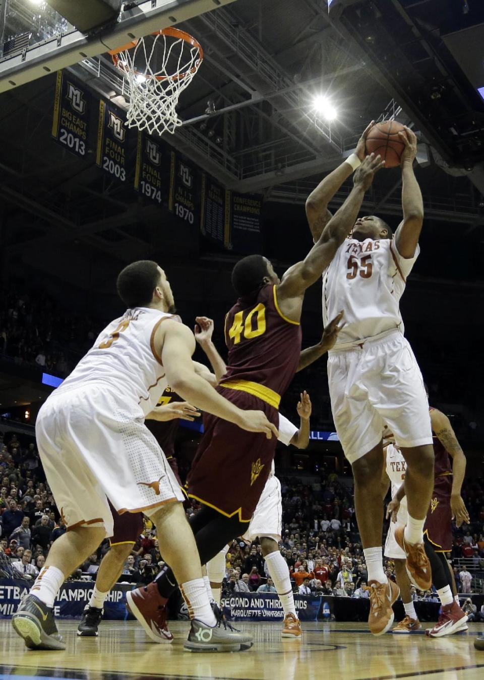 Texas center Cameron Ridley (55) goes up for the game winning shot against Arizona State during the second half of a second-round game in the NCAA college basketball tournament Thursday, March 20, 2014, in Milwaukee. Texas won 87-85. (AP Photo/Morry Gash)