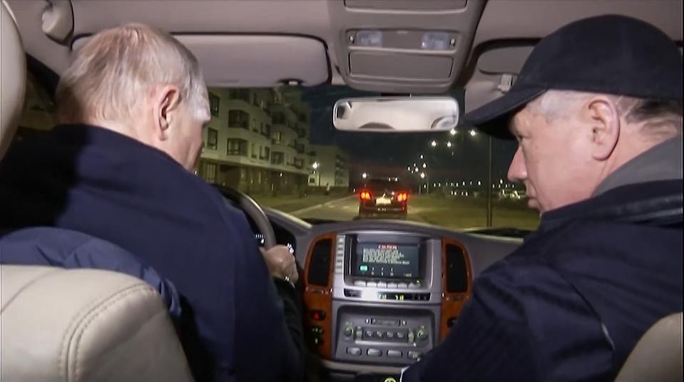In this photo taken from video released by Russian TV Pool on Sunday, March 19, 2023, Russian President Vladimir Putin, left, and Russian Deputy Prime Minister Marat Khusnullin drive a car during their visit to Mariupol in Russian-controlled Donetsk region, Ukraine. Putin has traveled to Crimea to mark the ninth anniversary of the Black Sea peninsula's annexation from Ukraine. (Pool Photo via AP)