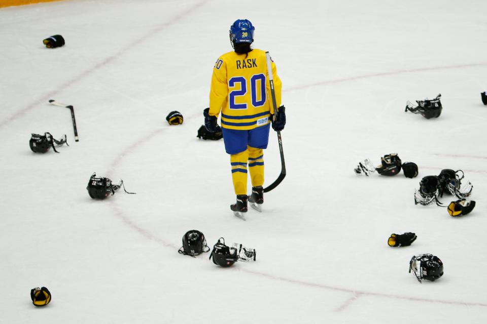 Fanny Rask of Sweden (20) skates through Team Switzerland helmets and gloves after loosing 4-3 in the women's bronze medal ice hockey game at the 2014 Winter Olympics, Thursday, Feb. 20, 2014, in Sochi, Russia. (AP Photo/Julio Cortez)