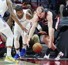 Portland Trail Blazers center Cody Zeller, right, and Los Angeles Clippers guard Paul George reach for the ball during the first half of an NBA basketball game in Portland, Ore., Monday, Dec. 6, 2021. (AP Photo/Craig Mitchelldyer)