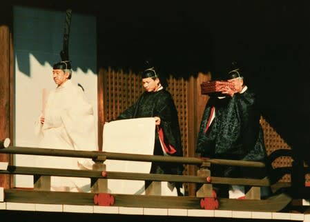 FILE PHOTO: Emperor Akihito walks ahead of priests prior to ceremonies marking his accession to Japan's Chrysanthemum Throne